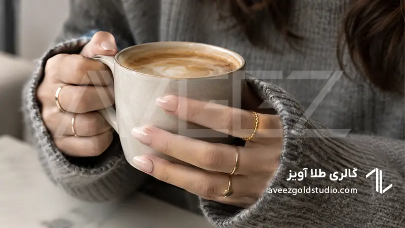  ترکیب انگشترهای مینیمال طلا با استایل مونوکروم طوسی در فضای کافه لایف‌استایل